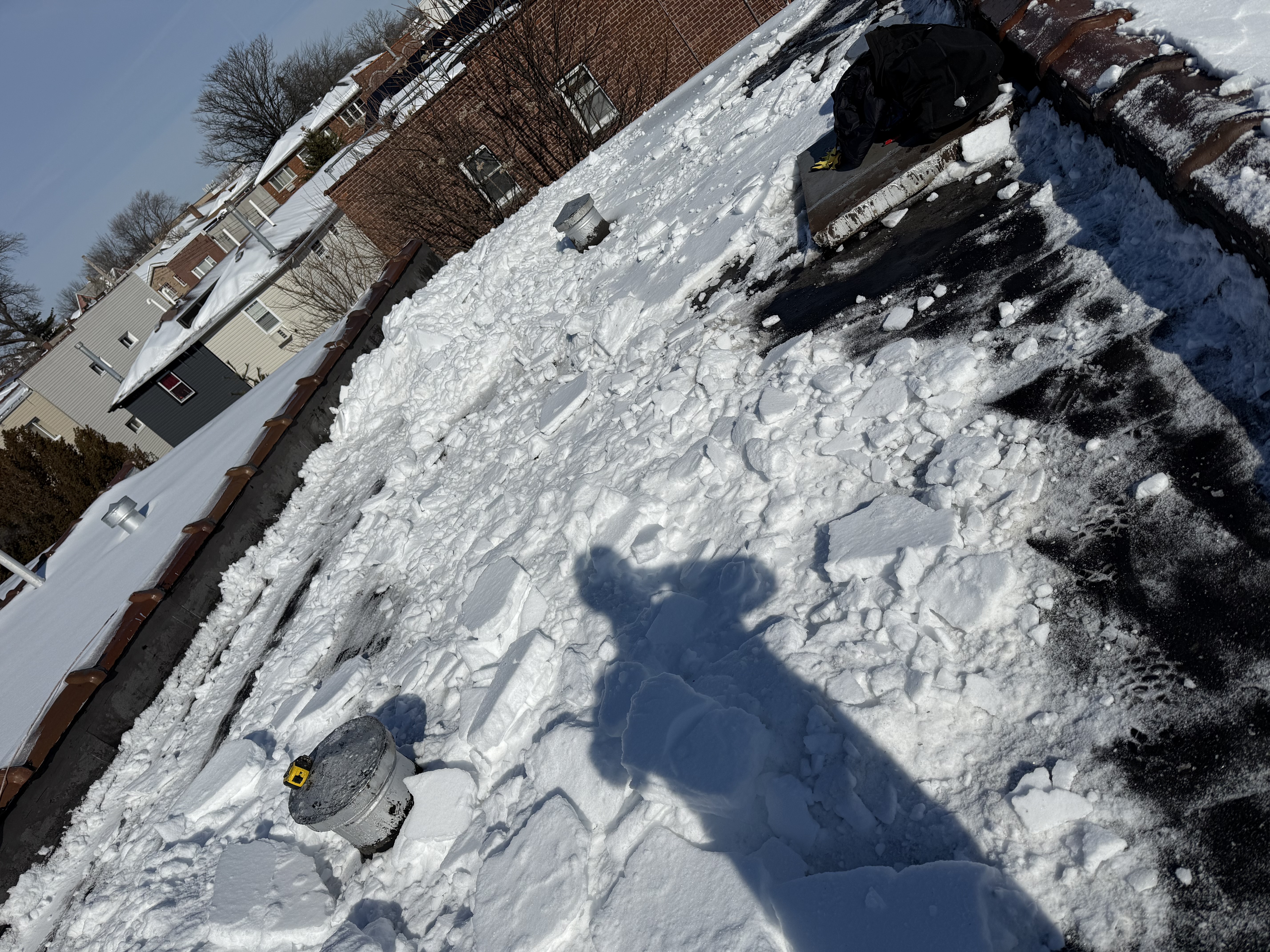 Flat roof covered with snow and ice in Queens requiring removal